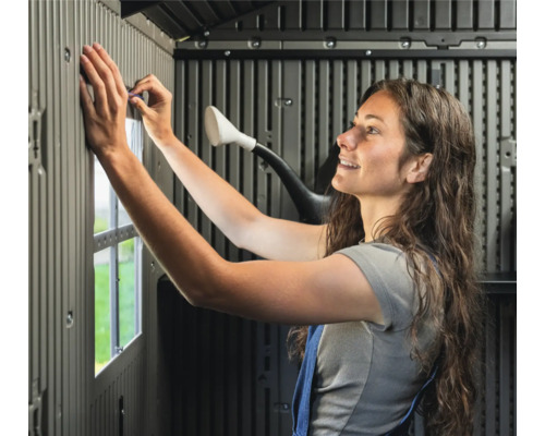 Femme assemblant un abri de jardin en plastique