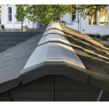 Gros plan d'un toit de cabanon de jardin avec des bardeaux et une fenêtre de toit