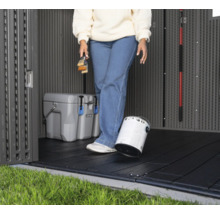 Vue intérieure d'une remise de jardin avec des dalles de sol, un pot de peinture et une glacière