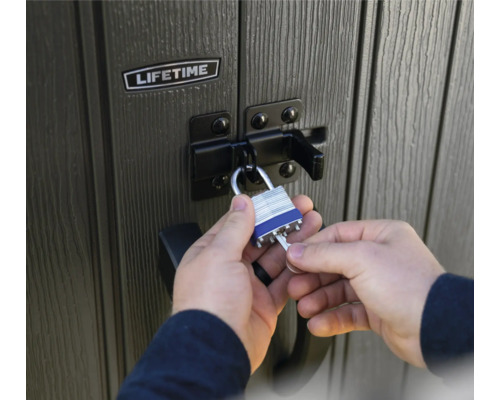 Une personne ferme un abri de jardin Lifetime avec un cadenas