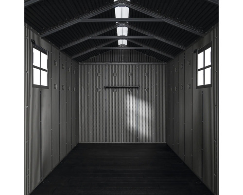 Vue intérieure d'un abri de jardin avec fenêtres et murs en métal.