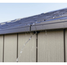 L'eau s'écoule du toit d'une cabane de jardin.