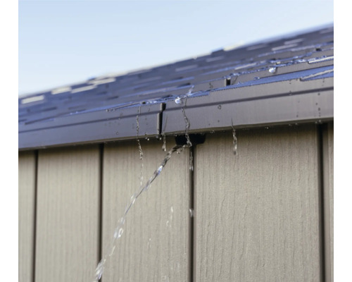 L'eau s'écoule du toit d'une cabane de jardin.