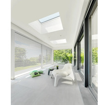 Pièce lumineuse avec fenêtres de toit, stores et porte coulissante