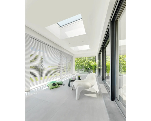 Pièce lumineuse avec fenêtres de toit, stores et porte coulissante