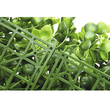 Detailansicht eines künstlichen Pflanzenpaneels mit grünen Blättern und Kunststoffgitter