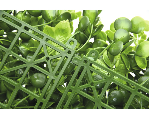 Detailansicht eines künstlichen Pflanzenpaneels mit grünen Blättern und Kunststoffgitter