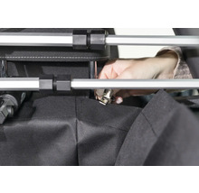 Person befestigt Stoff mit Klemme an einem Rahmen