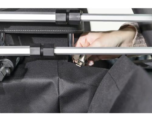 Person befestigt Stoff mit Klemme an einem Rahmen