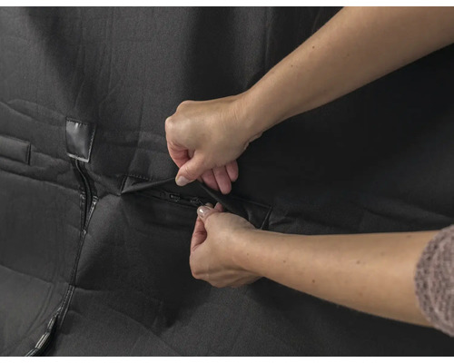 Schutzhülle mit Reissverschluss wird von Händen geschlossen