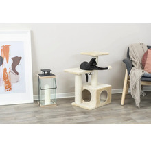 Chat jouant sur un arbre à chat avec niche et plateformes dans le salon.