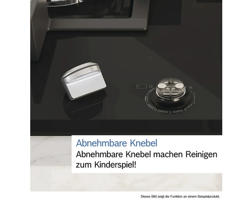 Detailansicht eines abnehmbaren Bedienknopfes auf einem schwarzen Kochfeld