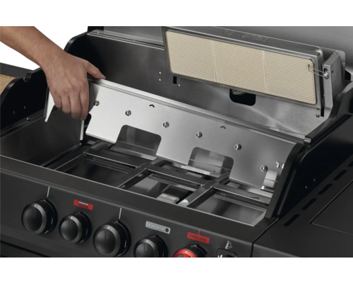 Gros plan d'un barbecue à gaz avec une main plaçant un couvercle.