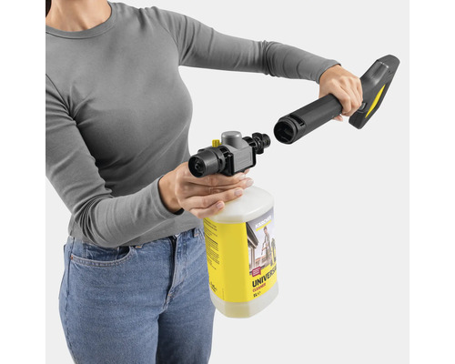 Une femme fixe une buse à un flacon de nettoyant universel pour nettoyeurs haute pression.