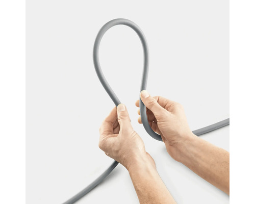 Un tuyau gris est tenu par deux mains.