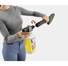 Une personne fixe un pulvérisateur de mousse sur un pistolet de nettoyeur haute pression Kärcher avec nettoyant universel.
