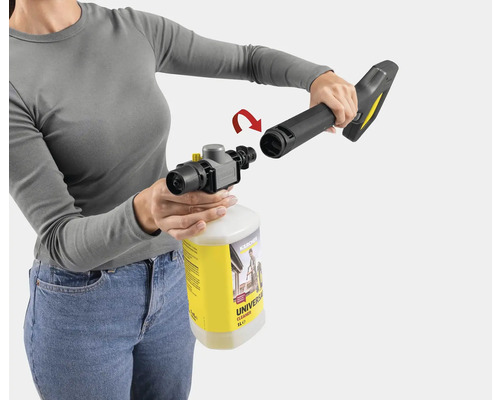 Une personne fixe un pulvérisateur de mousse sur un pistolet de nettoyeur haute pression Kärcher avec nettoyant universel.