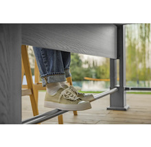 Personne assise à table avec un jean et des baskets