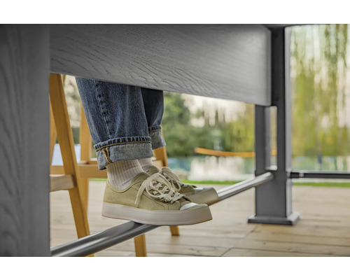 Personne assise à table avec un jean et des baskets