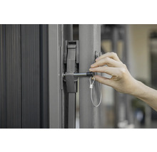 Vue détaillée d'un portail avec un mécanisme de fermeture et une personne l'actionnant