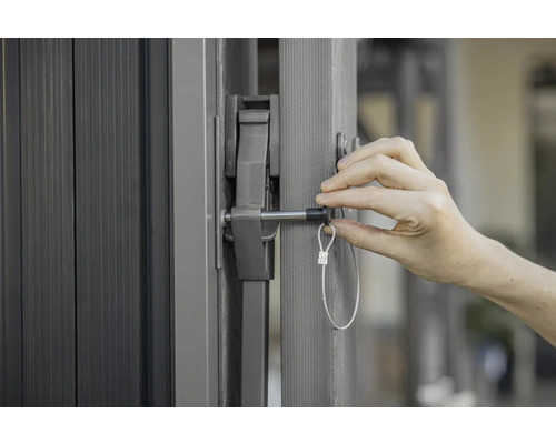 Vue détaillée d'un portail avec un mécanisme de fermeture et une personne l'actionnant