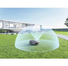 Rasenmähroboter auf Rasenfläche mit modernem Haus im Hintergrund