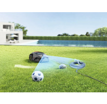 Szene mit Rasenmähroboter, Fussball, Gartenbewässerungssystem und Stein auf einer Rasenfläche
