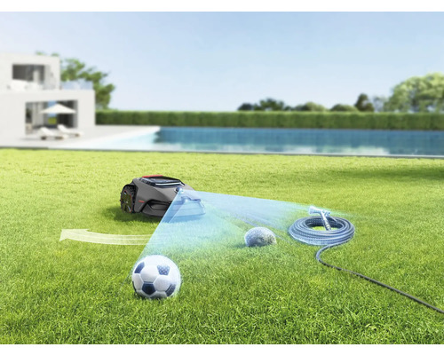 Szene mit Rasenmähroboter, Fussball, Gartenbewässerungssystem und Stein auf einer Rasenfläche