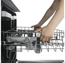 Un lave-vaisselle avec un panier à vaisselle sorti et manipulé par des mains.