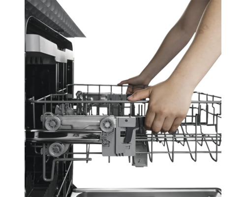 Un lave-vaisselle avec un panier à vaisselle sorti et manipulé par des mains.