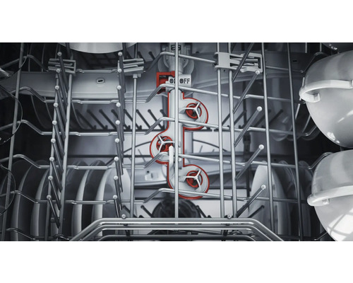 Vue intérieure d'un lave-vaisselle avec de la vaisselle et un bras d'aspersion