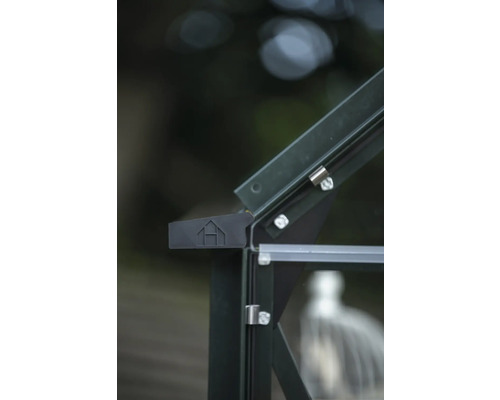 Detailansicht eines Gewächshauses mit Glaseinsätzen und einem Emblem.