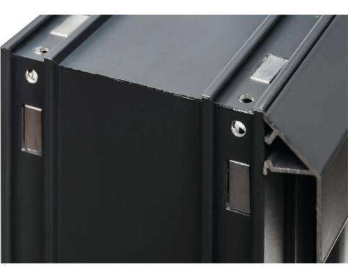 Gros plan sur un profilé en aluminium noir avec trous et aimants