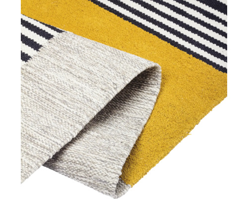 Detailansicht eines Teppichs mit Streifenmuster und aufgerolltem Ende