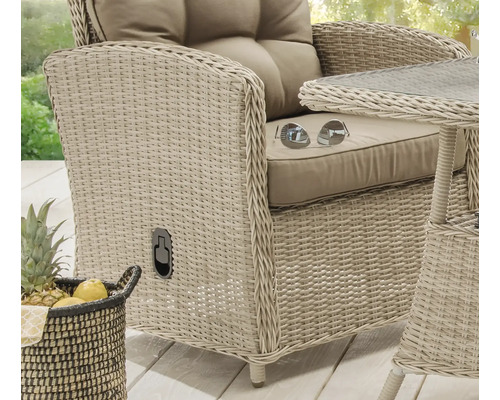 Nahaufnahme eines Korbsessels mit Kissen und einem kleinen Tisch