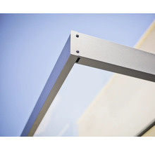 Vue détaillée du raccord de coin pour marquise avec cadre métallique et élément en verre.