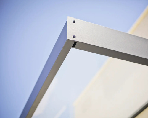 Vue détaillée du raccord de coin pour marquise avec cadre métallique et élément en verre.