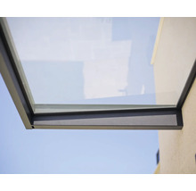 Marquise moderne en verre avec cadre métallique anthracite sur un mur extérieur.