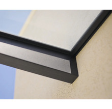 Détail d'un cadre en aluminium sombre pour une toiture de terrasse avec élément en verre sur un mur extérieur.