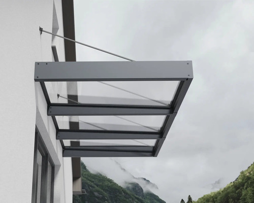 Modernes Vordach aus Glas mit anthrazitfarbenem Aluminiumrahmen, montiert an einer Hauswand mit Zugstangen.