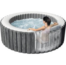 Jacuzzi gonflable rond avec habillage en bois et femme