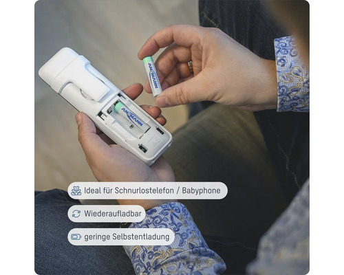 Eine Person legt eine Ansmann Batterie in ein schnurloses Telefon ein.