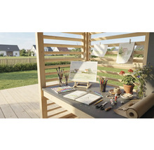 Espace de travail créatif en extérieur avec chevalet, peintures, pinceaux, papier et fleurs