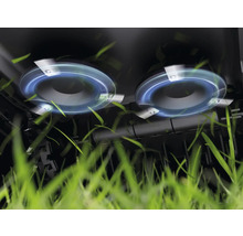 Gros plan du carter de coupe d'une tondeuse à gazon coupant l'herbe