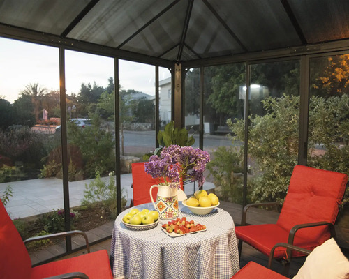 Überdachter Sitzbereich mit Tisch, Blumen und rotem Mobiliar