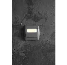 Eingeschalteter Lichtschalter an einer Wand