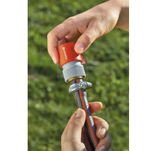 Eine Person befestigt einen Gardena Schlauchverbinder an einem Gartenschlauch.