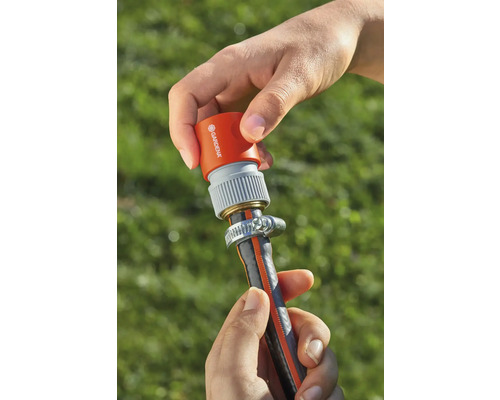 Eine Person befestigt einen Gardena Schlauchverbinder an einem Gartenschlauch.