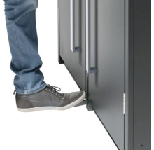 Person öffnet Möbeltür mit Fussbedienung