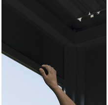 Une main actionne un store enrouleur sur un pavillon.